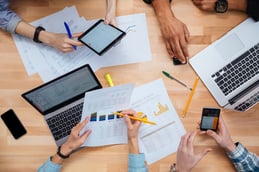 Group of people working with laptops, tablet and smartphones together and making financial report