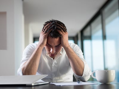 frustrated with problems young business man working on laptop computer at home